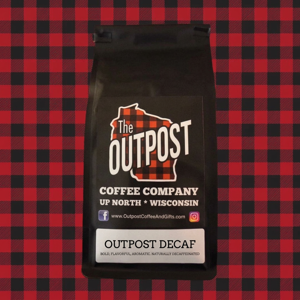 Outpost Decaf coffee bag on red and black plaid, labeled bold, flavorful, aromatic, naturally decaffeinated